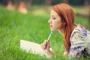 woman writing in grass