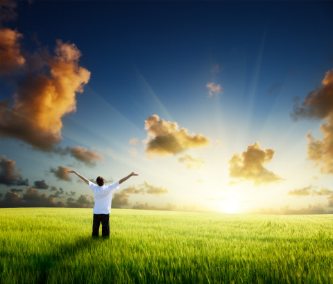 man with outstretched hands in sunlight