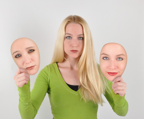 woman holding masks of herself