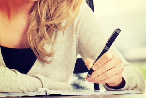 woman writing plan in notebook, clarifying vision for her life