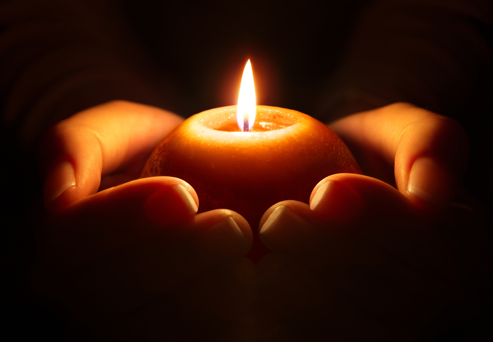 2 hands holding candle