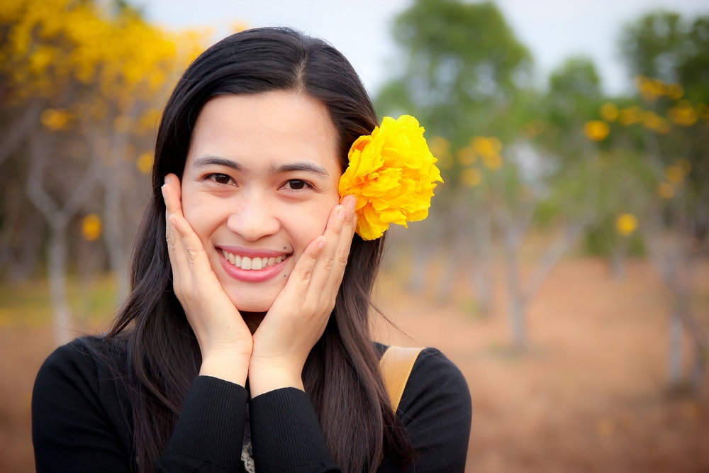 smiling woman with yellow flower