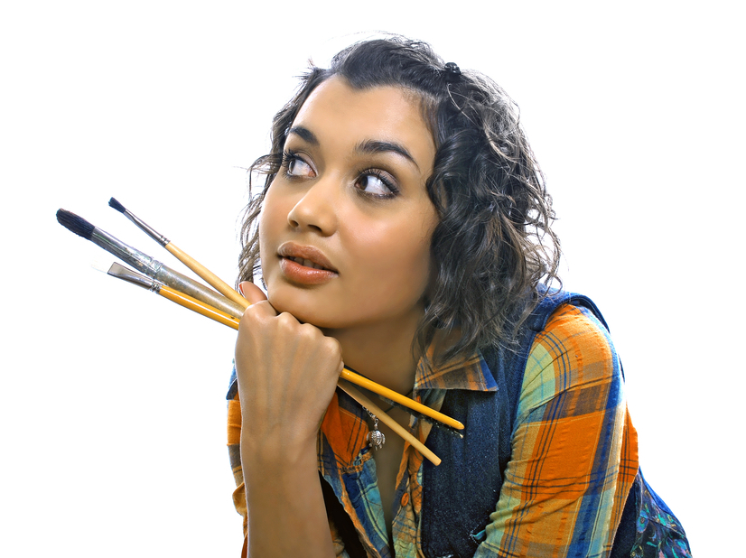 contemplative woman holding paintbrushes