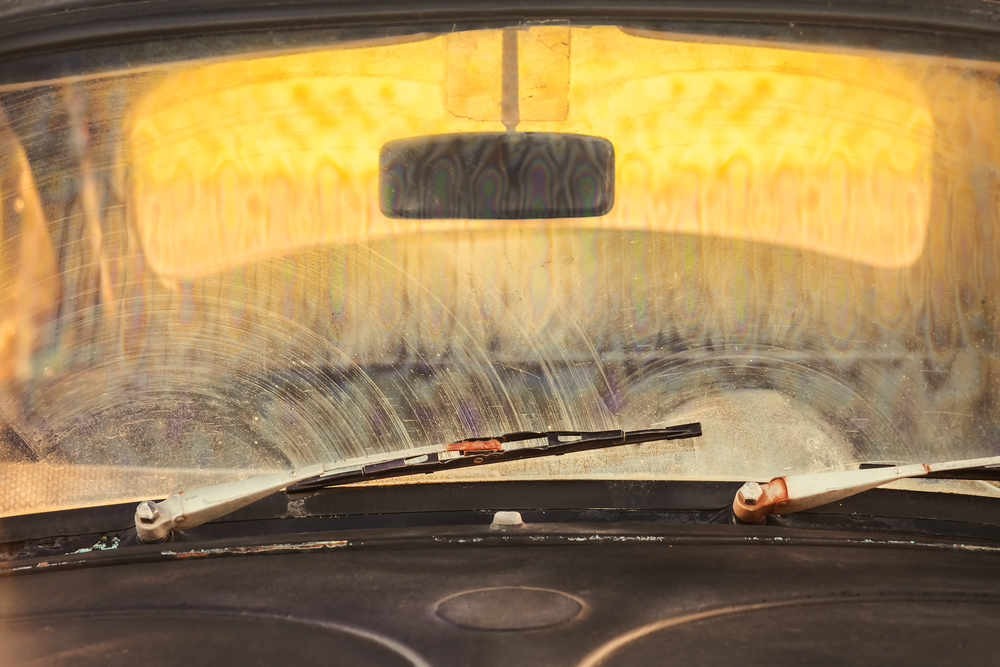 Looking out of car with an extremely dirty windshield.