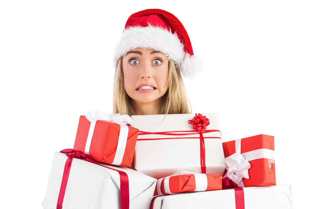 Holiday overwhelm and stress too much to deal with? (Frantic looking woman under huge load of wrapped presents.)