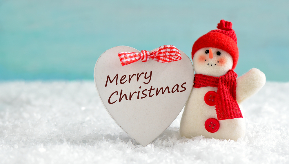 Snowman with "Merry Christmas" heart sign. Happy holidays, love peace and joy!