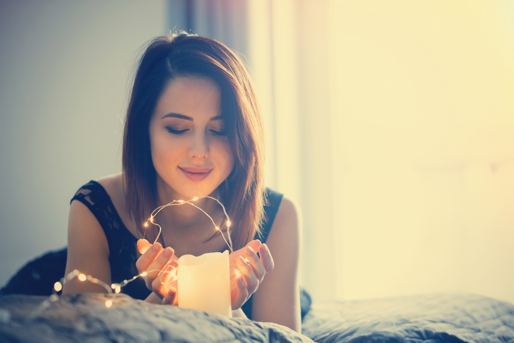 What is a lightworker? Woman peacefully contemplating with candle.