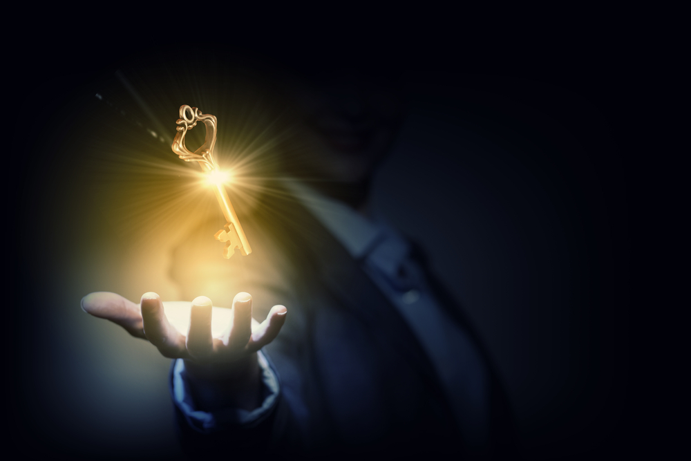 The second key - manifestation and truth. A golden key hovering above a man's hand