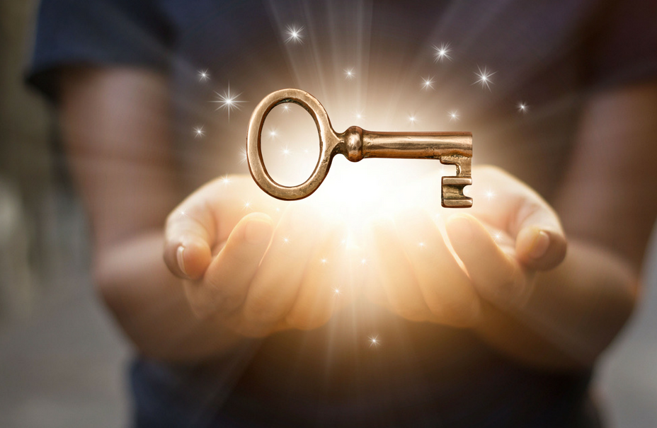 Hands holding a key radiating light. Envision the life of your dreams!